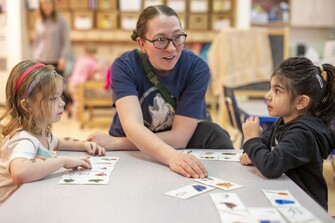 teacher working with young students with flashcards