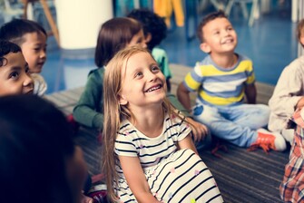 students sitting on ground in classroom